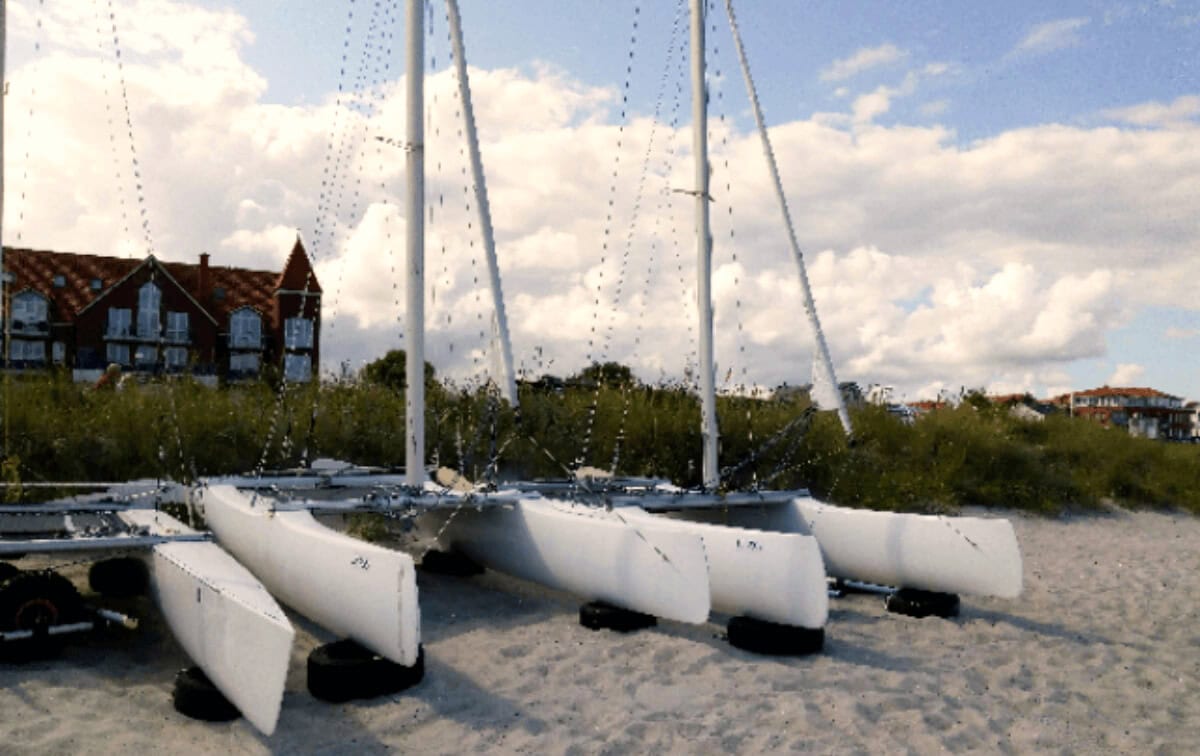 Segelboote am Strand mit Pikestiefeln, maritime Wasserfahrzeuge, entspannte Segeltage, Bootsmaterialien, Strandurlaub, Wasserport, Outdoor-Aktivitäten, Sommer, Urlaub.